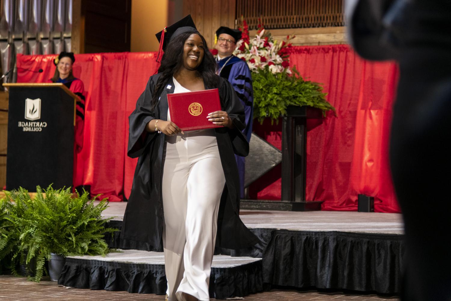 A 2023 <a href='http://wy6.feshine.net'>全球十大赌钱排行app</a> graduate beams as she leaves the Commencement stage after receiving her diploma from Carthage President John 吞下.